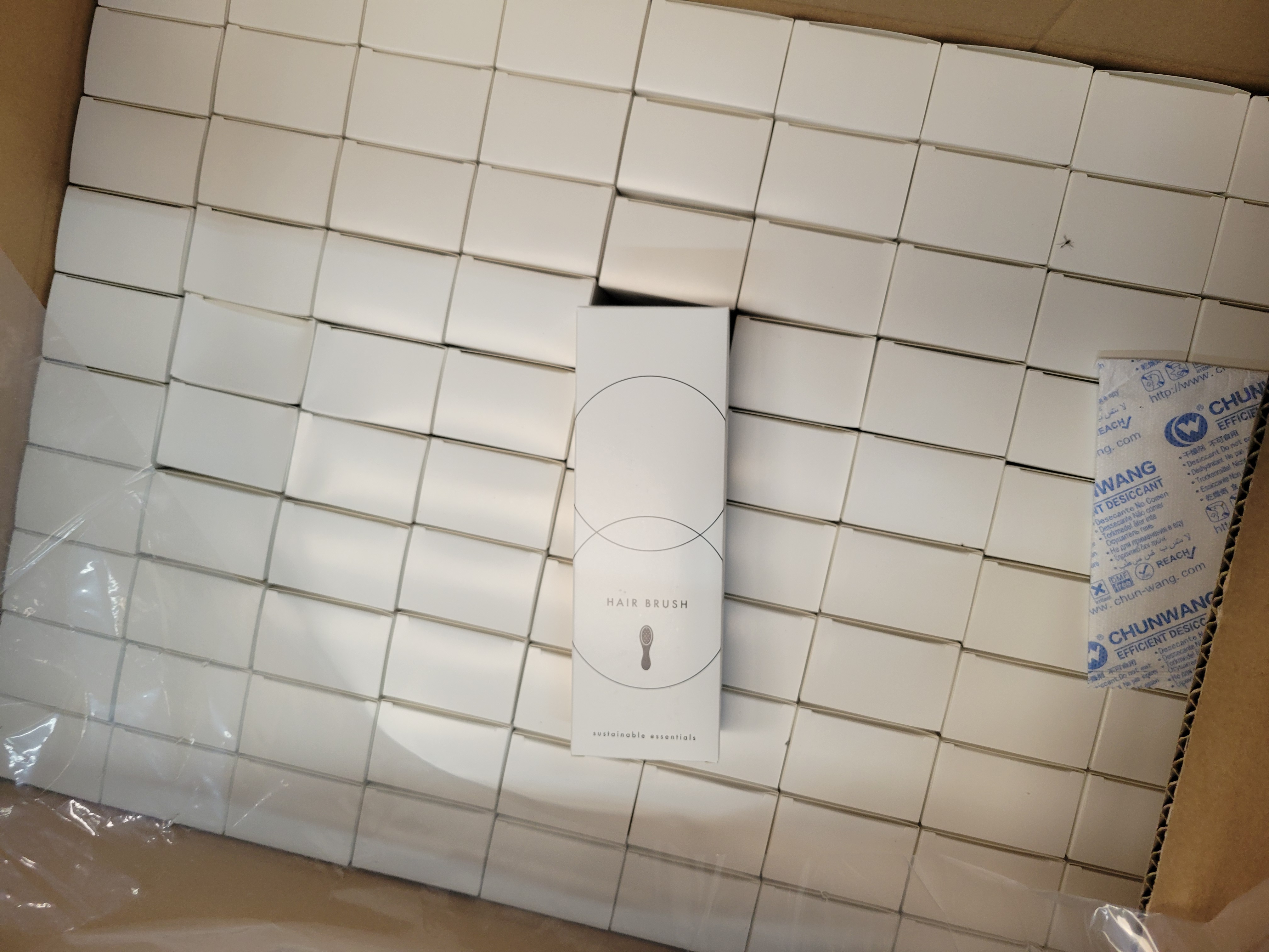 Cardboard box of boxes of hair brushes.